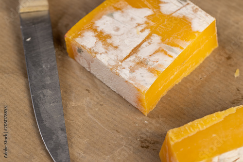 old orange cheese covered in mold, spoiled cheese