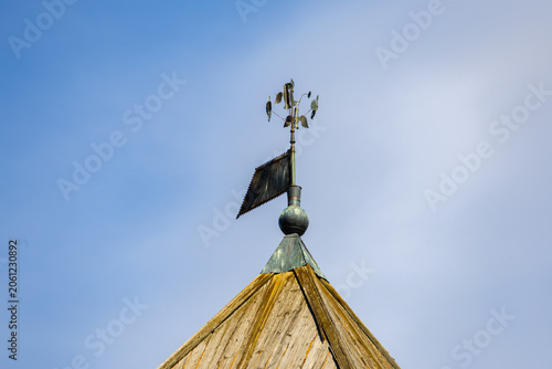 Cuadro en lienzo Antique copper weathervane on wooden shingle spire against blue sky
