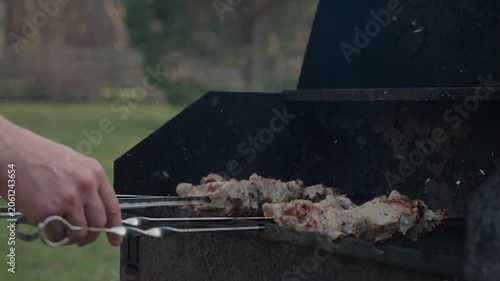 Fresh marinated meat grilling on metal skewers over hot charcoal and open flame