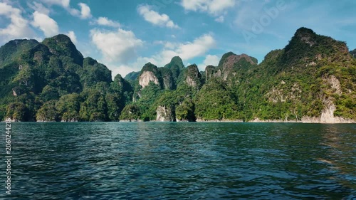 Khao sok national park lake view from boat in Thailand. Tracking shot of wooden boat bow gliding across mountain lake.