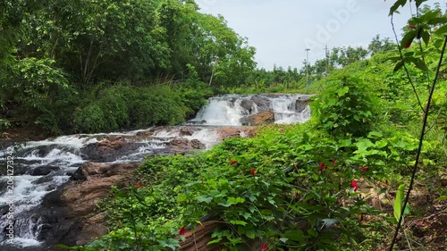 A  flowing freshwater stream in the western ghats of Kerala, India, showcasing natural movement, rippling water, and a tranquil outdoor environment.