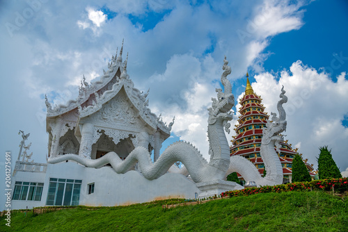 Photography Beautiful white temple with giant naga snake statues and nine story Chinese pagoda on a green hill under blue sky at Wat Huay Pla Kang, Chiang Rai, Thailand