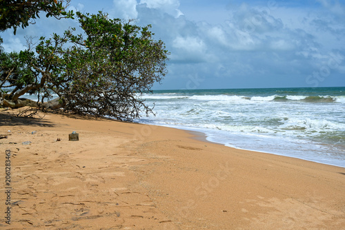 Φωτογραφία Tropical sandy beach coastline with sea waves crashing on the shore