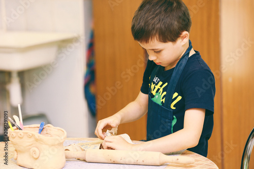a cute boy sculpts from clay