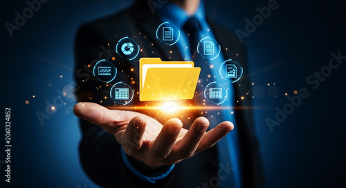 Man holding glowing yellow folder with digital data icons floating around hand