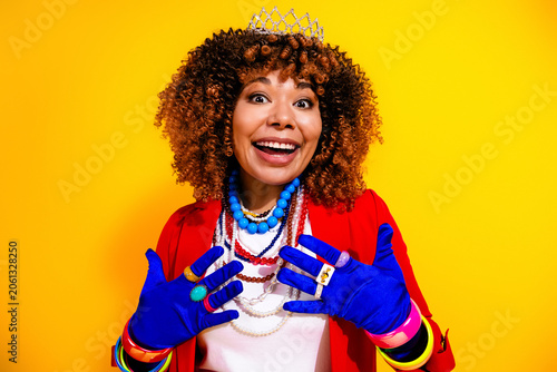 Tableau sur toile Smiling woman wearing a tiara and bright vintage jewelry with colorful gloves an