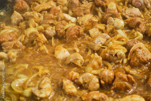 Cooking paella with chicken in a frying pan. Selective focus.
