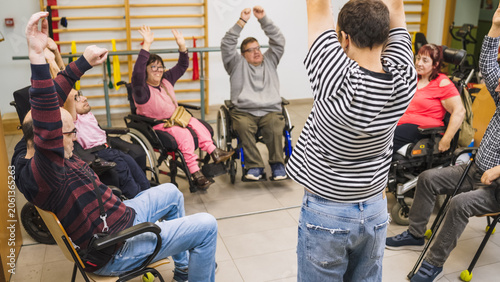 Diverse group of people with disabilities and a physiotherapist engaging in rehabilitation exercises, promoting health and inclusion
