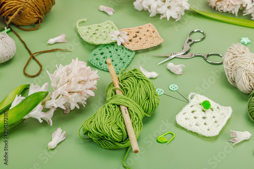 Creative hobby and handmade craft concept. Flat lay of crochet granny squares, yarn skeins, crochet