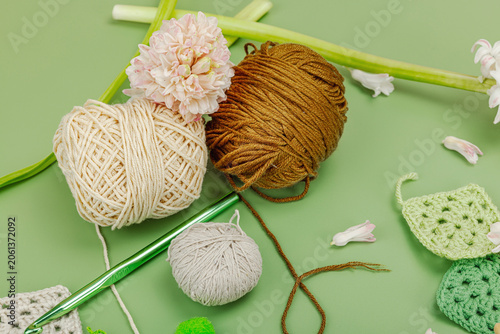 Creative hobby and handmade craft concept. Flat lay of crochet granny squares, yarn skeins, crochet
