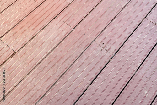 Reddish-brown composite decking boards with linear grooved texture background.