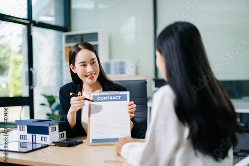Foto Real estate broker agent presenting and consult to customer to decision making sign insurance form agreement, home model, concerning mortgage loan offer