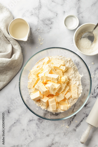 Process of making a base for shortbread pie, tart or quiche. Butter and flour mixture in a deep glass bowl. Home baking culinary concept, recipe. Top view