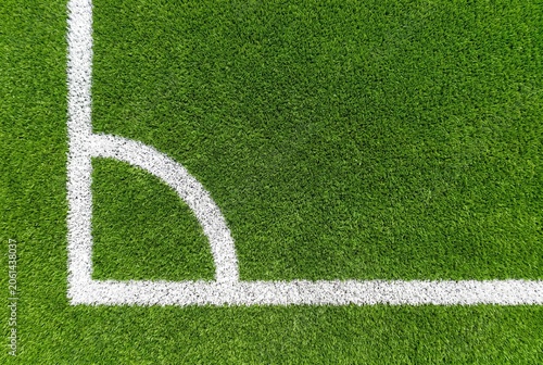 Top view of a professional football field corner with bright white painted lines on vibrant green synthetic turf grass texture for sports events