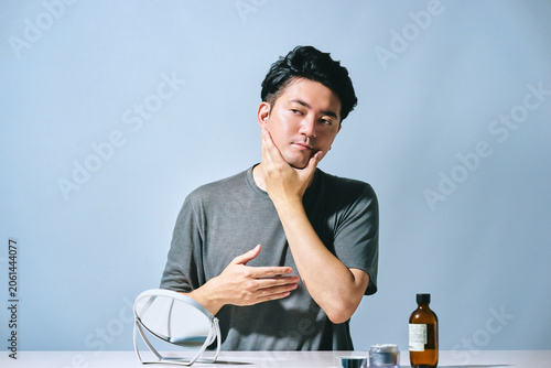 Fotografía 爽やかで清潔感のある30代の日本人男性が顔に触れてスキンケアをするスタイリッシュな美容のイメージ