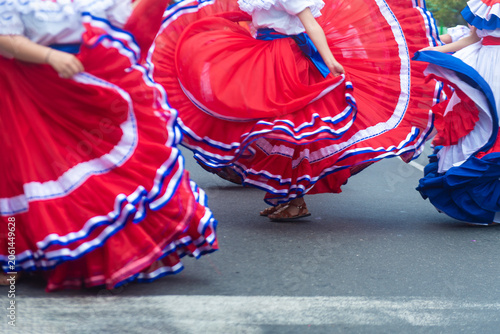 Bild auf Leinwand Women performing a folk dance in vibrant traditional clothing during a festive event