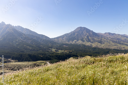 Majestic Volcanic Mountain Range Under Clear Blue Sky with Green Grassland