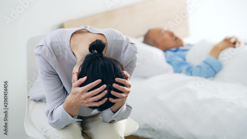 Foto 昏睡するシニア男性と悩む女性