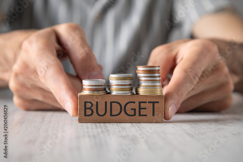 Man showing Budget word with a coins.