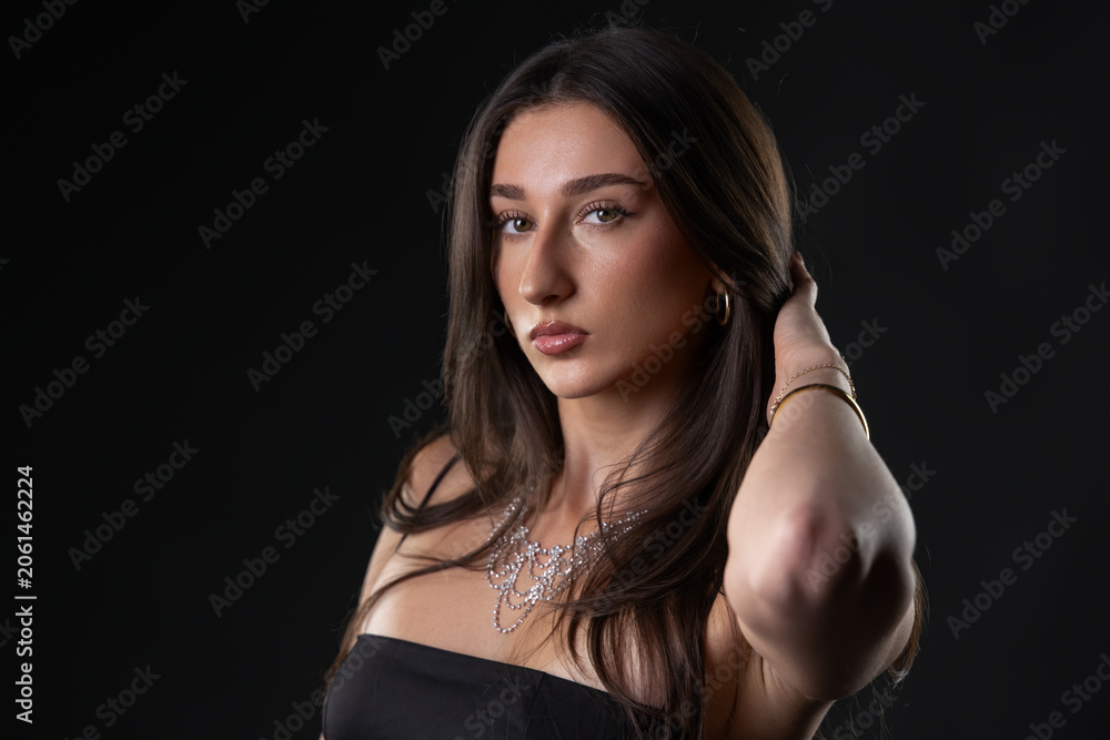 Fototapeta premium Beautiful young woman modeling jewelry and fashion in a studio portrait