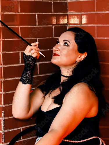Woman portraying 1920s flapper style holding cigarette holder