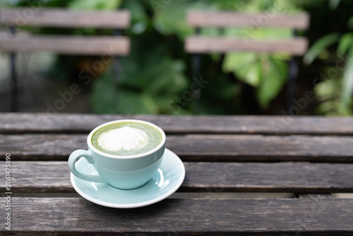 Matcha latte in a teal cup on old grunge wooden table