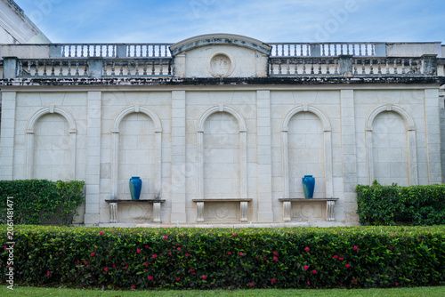 Elegant Stone Wall with Arches and Garden Hedge