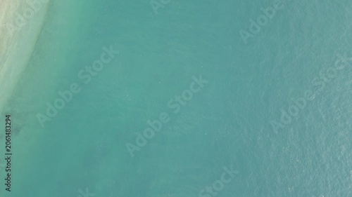 Top Down Aerial Of Turquoise Shallows Meeting Sandy Beach Edge