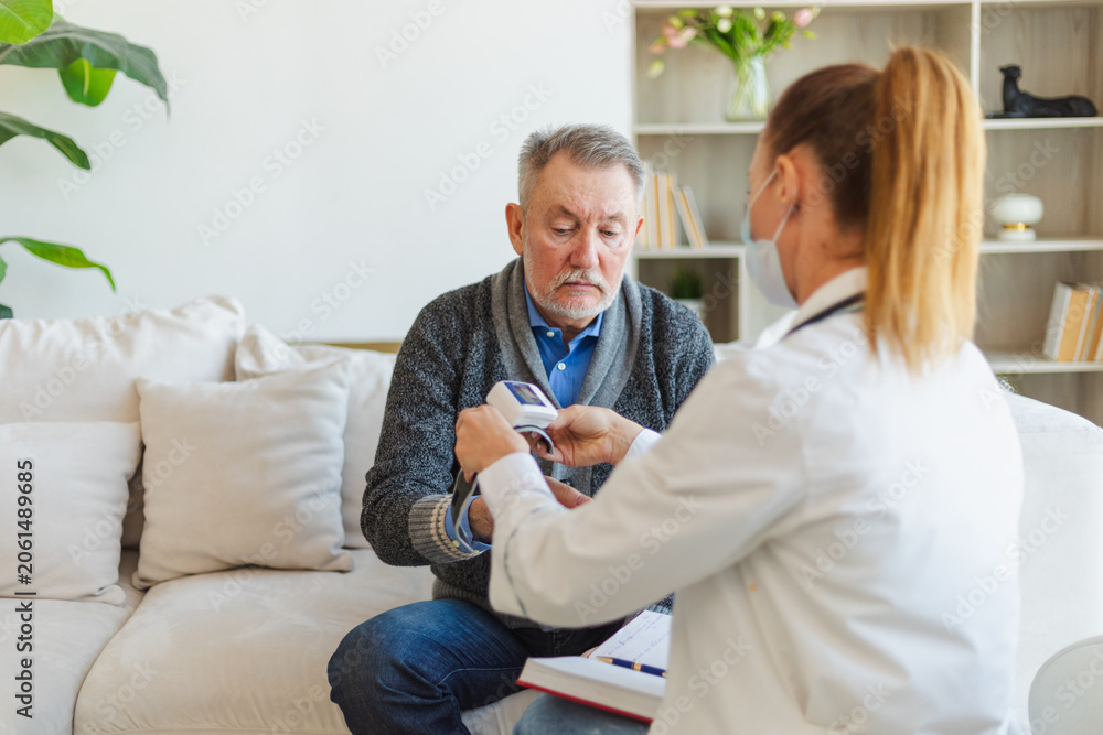 Fototapeta premium Female doctor senior man taking his blood pressure in doctor office or at home. Old man patient and doctor have consultation in hospital room. Medicine healthcare medical checkup. Visit to doctor