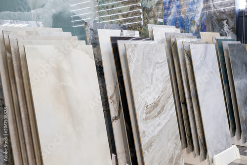Collection of natural stone, marble and ceramic tile samples displayed in showroom. Various textures, patterns for interior design, renovation and construction projects. Building materials.