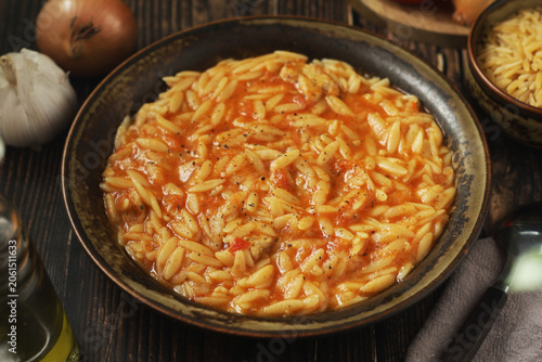 A bowl with traditional Greek soup Manestra with orzo pasta	
