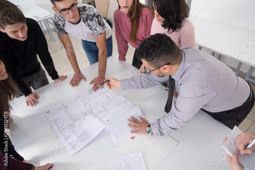 High Angle View of Diverse Architecture Students and Professor Discussing Blueprints
