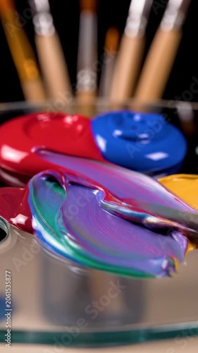 Colorful paintbrushes in metal tray with bright swatch lids