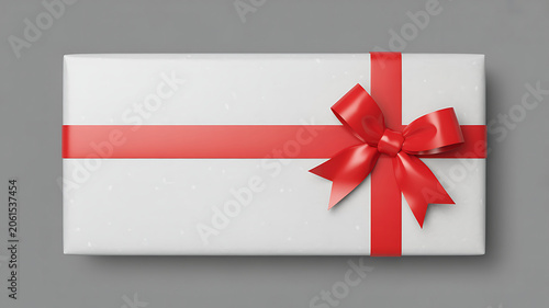A white gift box wrapped with a red ribbon and bow on top for christmas or birthday presents