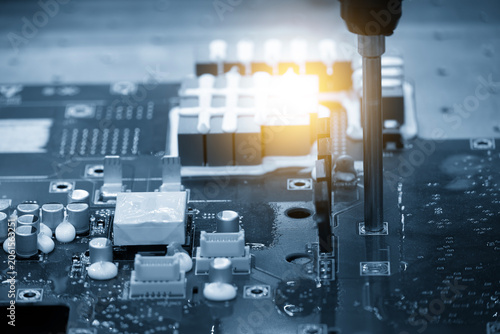 High-tech electronics circuit board assembly process executing by an automatic system in a blue tone scene.