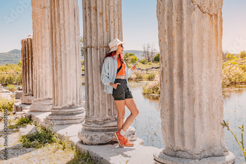 Fotografie Young woman exploring the ancient Temple of Miletus archaeological site on a sun