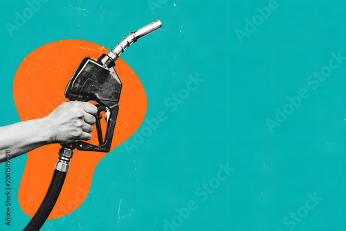 Hand Holding a Gas Pump Nozzle on Vibrant Teal Background