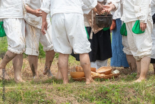 Traditional Korean rural ritual food served in wooden bowls on a basket during an agricultural folk festival reenactment.
