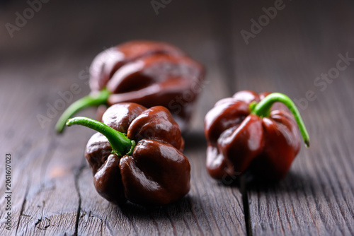 Schilderij op canvas Group of chocolate habanero peppers on wooden surface