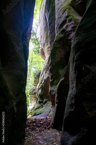 Massive sandstone rock formations along a forest trail in Bohemian Paradise (Cesky raj), Hruba Skala area (Hruboskalsko), Czech Republic, with giant stones rising above woodland path