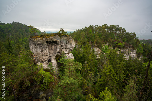 Rock city formations in Hruboskalsko, Bohemian Paradise (Cesky raj), Czech Republic, with peaks of giant sandstone rocks and cliffs emerging from light morning mist panoramic view