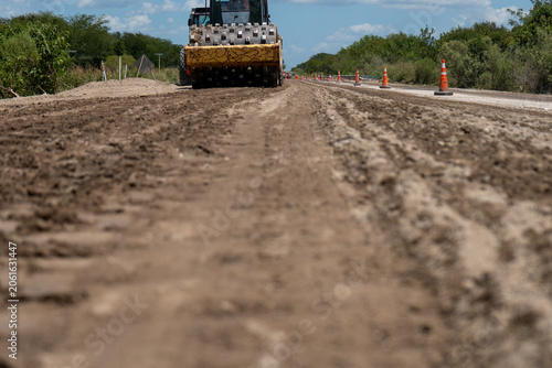 Obraz na plátně Heavy padfoot soil compactor working on leveling and flattening a dirt road at a construction site