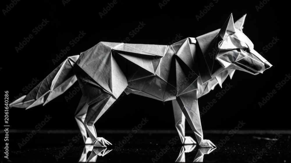 Obraz premium A black and white image of a paper cutout wolf in a simple composition