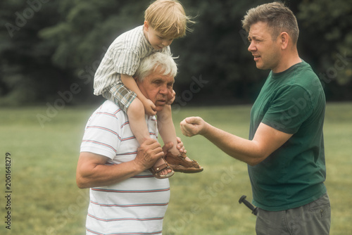 Obraz na plátně Happy senior man Grandfather with cute little boy grandson playing in field