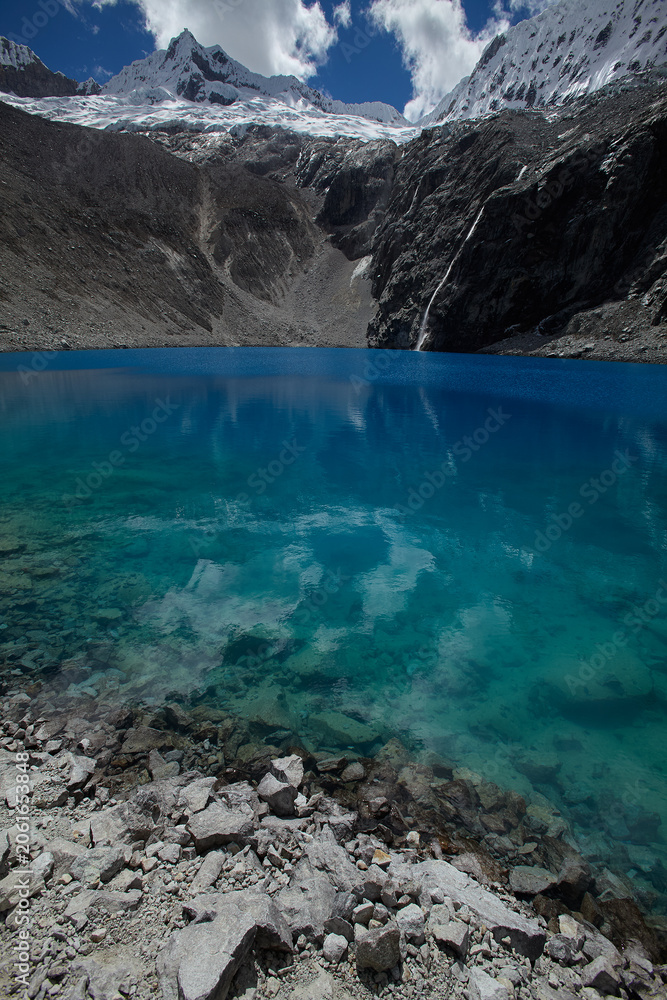 Fototapeta premium Laguna 69 burns with an almost supernatural intensity of color that stops every trekker who crests the final ridge in their tracks with the involuntary, unguarded reaction of someone encountering genu