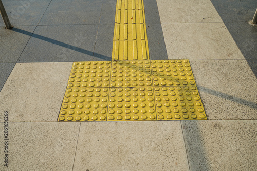 Fotografía Yellow tactile paving on sidewalk for visually impaired people