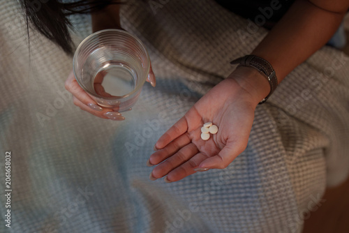 Fotografie Cropped hands holding glass of water and pills for medication dosage