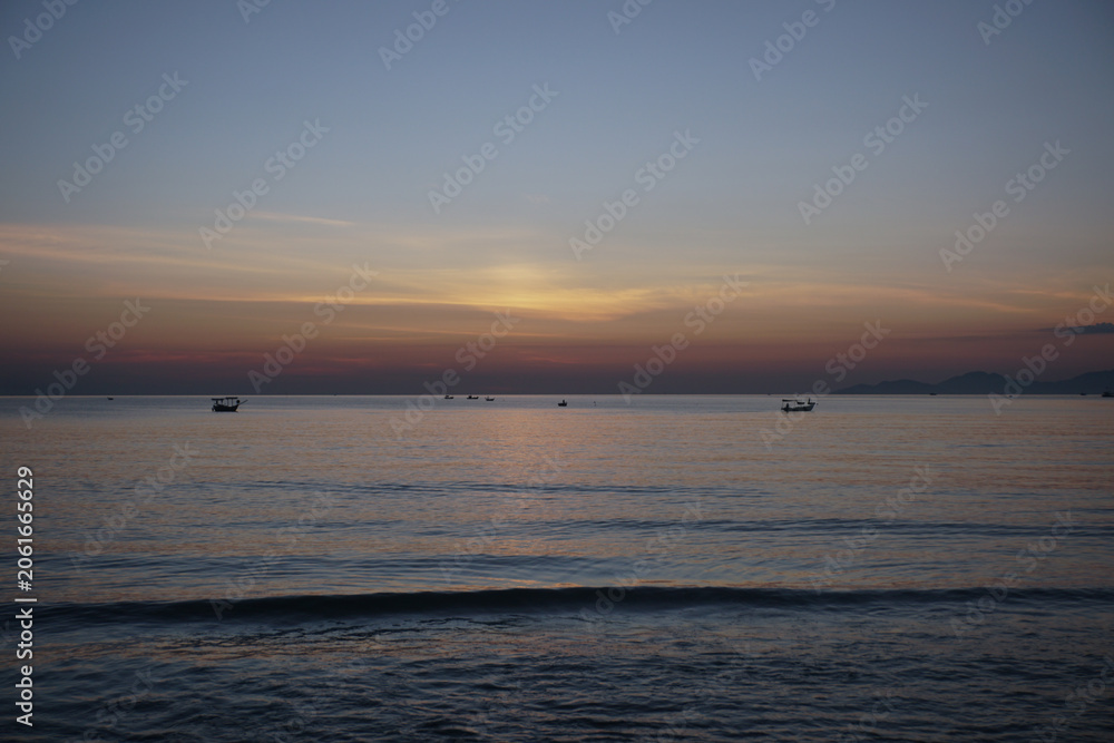Obraz premium Fishing boats at sea with sunrise in the background. Dawning sky before sunrise