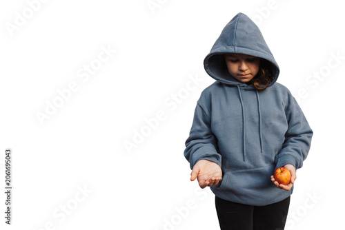 Fotografie A vulnerable child in a sweatshirt holding a small apple and extending an empty