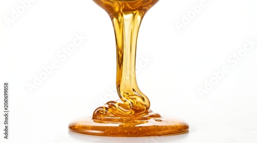 Golden sweet organic honey dripping onto a white surface